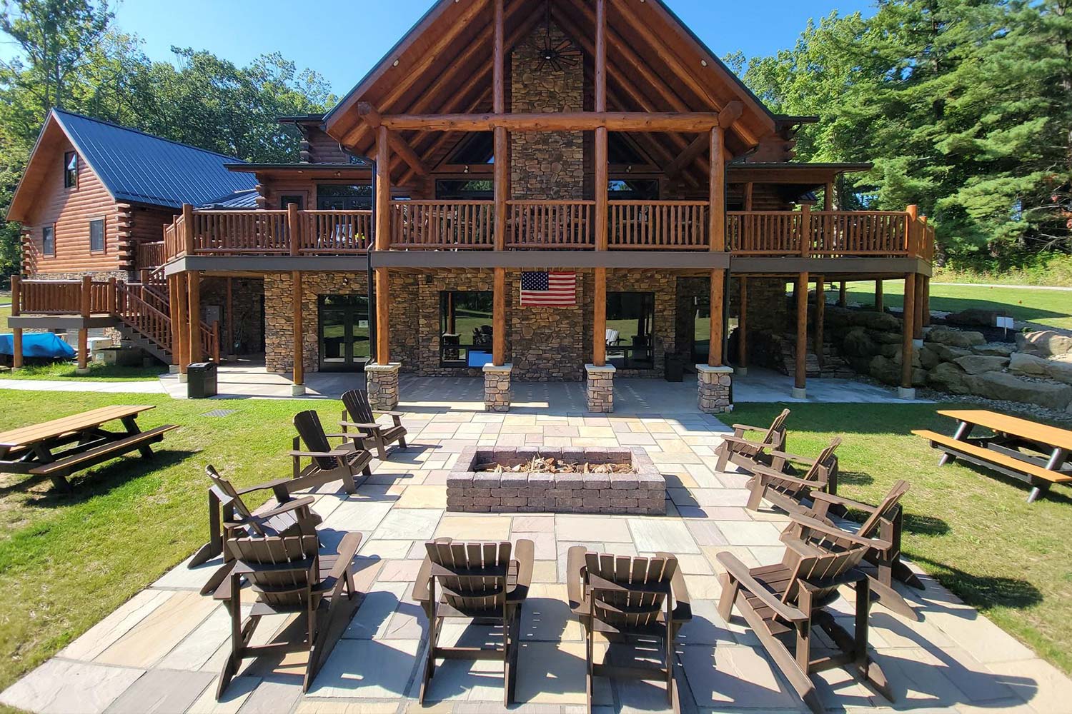 Back of Tyler's Redemption Place with a fire pit and chairs circled around it.