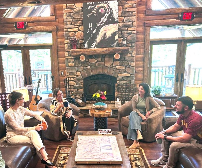 Group of people talking while sitting on couches, drinking coffee and relaxing.
